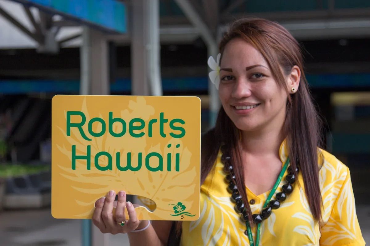 A Robert's Hawaii greeter welcoming arriving guests at the airport